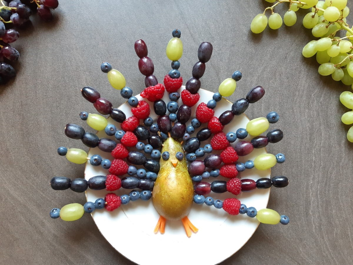 Duurzame schooltraktaties ideeën zoals deze fruitspiesjes in de vorm van een paauw.