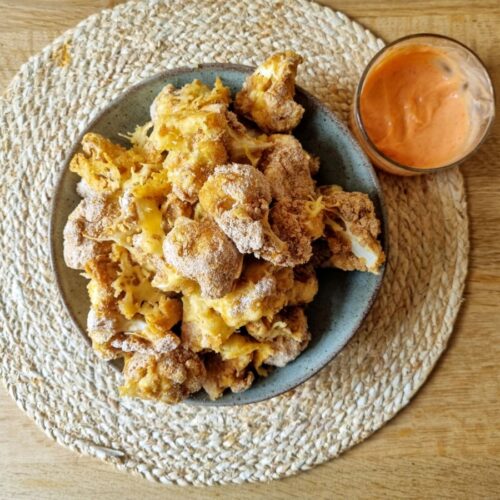 Bloemkool nuggets op een bord met dipsaus.