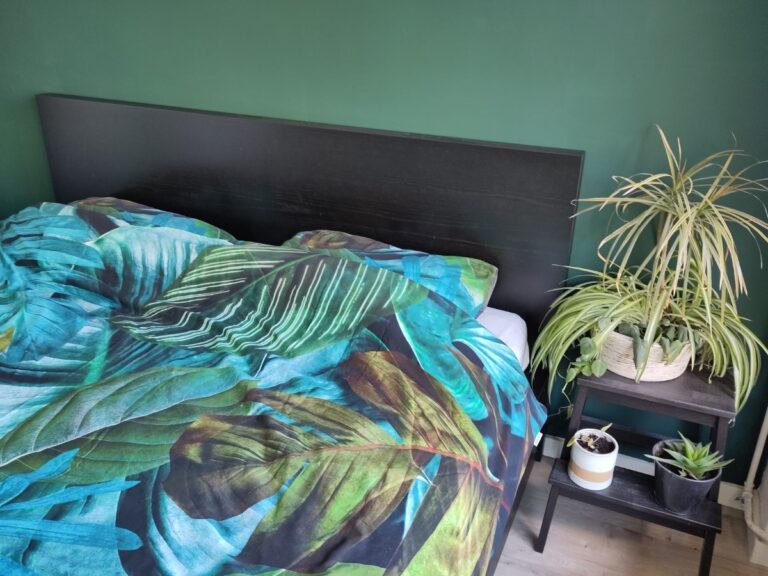 Duurzaam beddengoed met een botanische print op een opgemaakt bed.