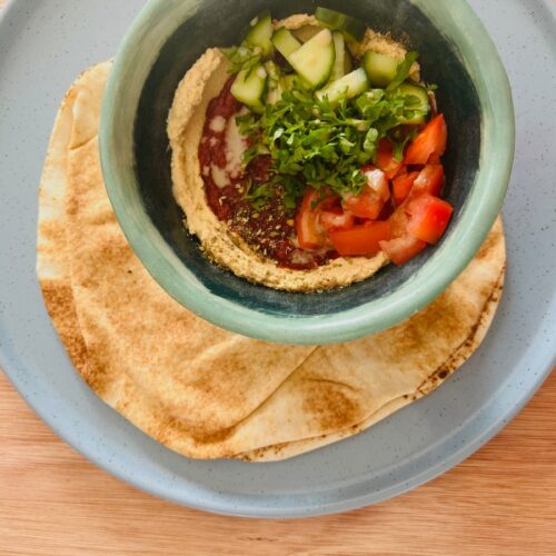 Hummusbowl met harissa-tomatensaus.