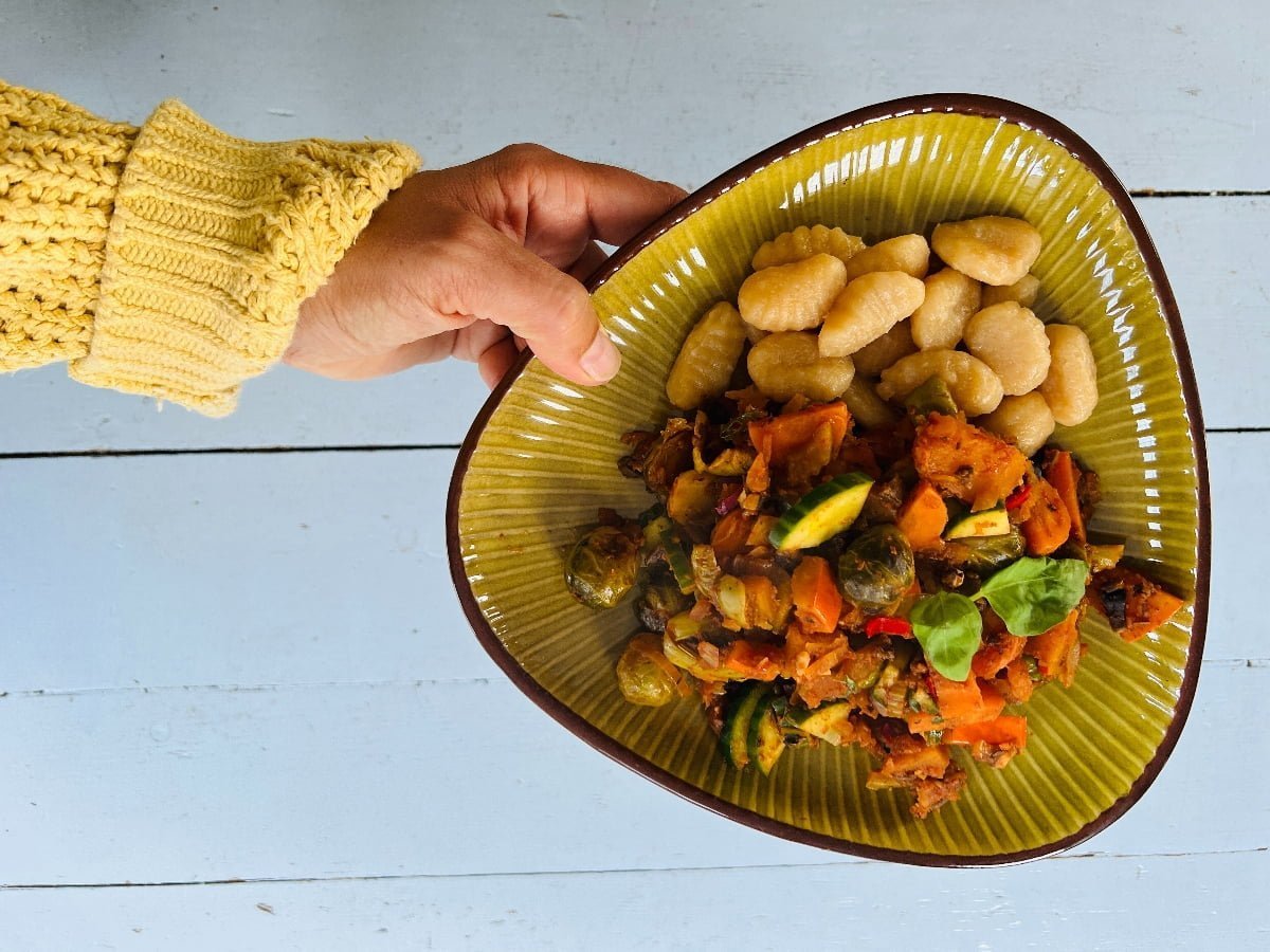 Mooi opgemaakt bord met gnocchi met groenten zoals spruitjes in tomatensaus.