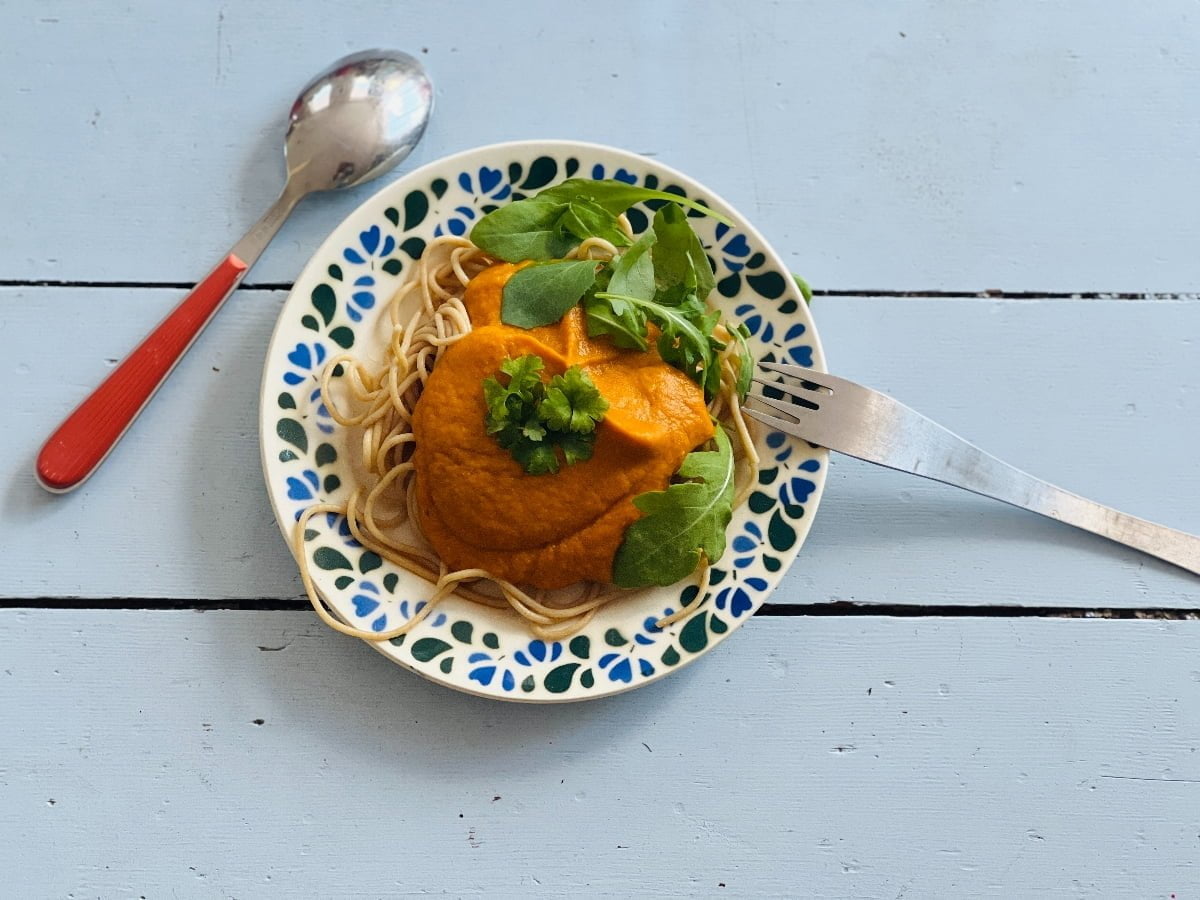 Oranje kindvriendelijke pastasaus met paprika, pompoen, zoete aardappel en tomaat.