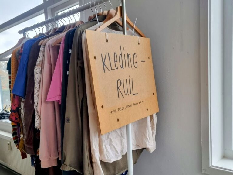 Tip bij het organiseren van een kledingruil: zorg voor een goed bord met huisregels en een kledingrek.