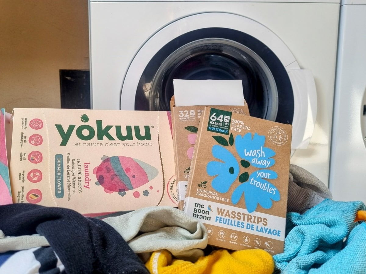 Verschillende milieuvriendelijke wasstrips op een berg vuile was voor wasmachine.